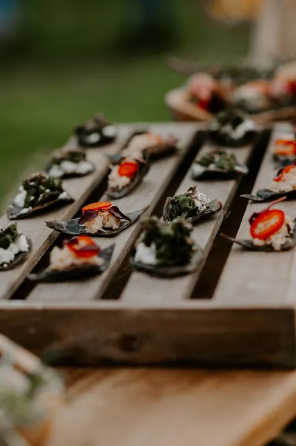 Canapés lined up on a wooden tray