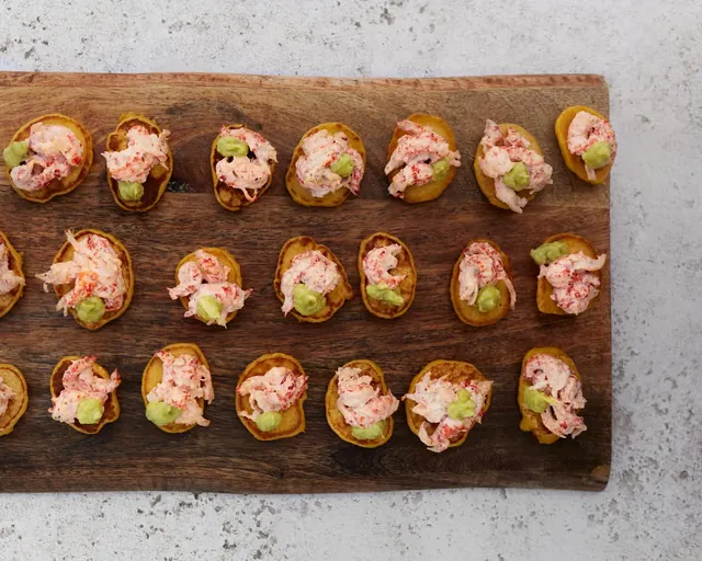 Crayfish and avocado on golden blinis