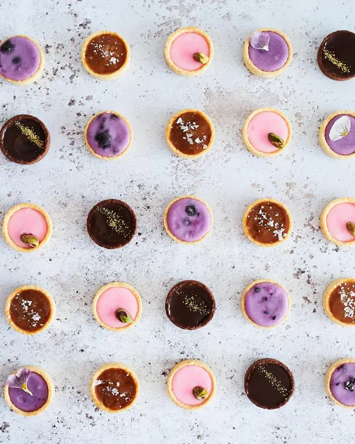 Rows of mini tarts: salted caramel, chocolate, raspberry and blueberry