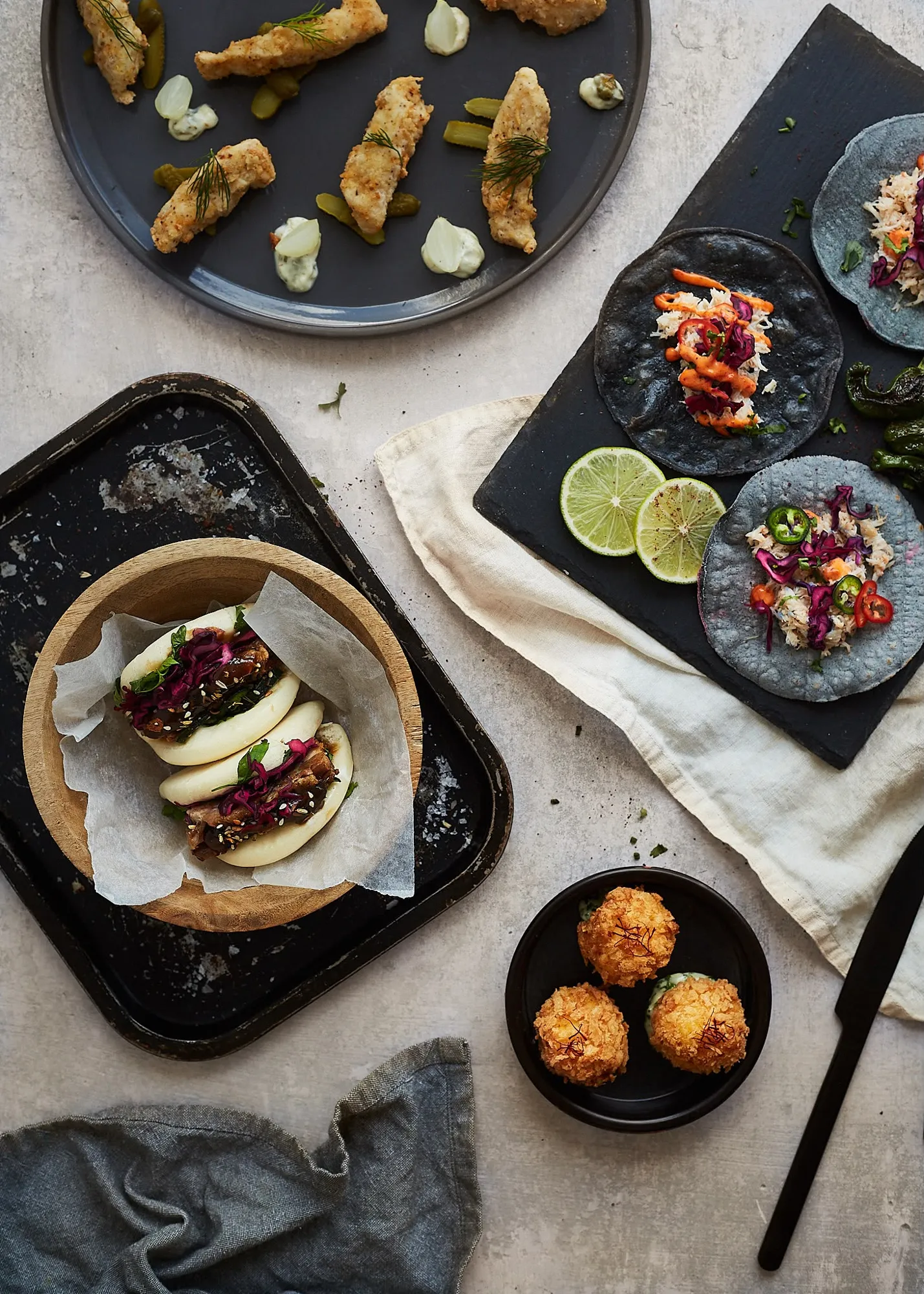 Supper club spread of bao buns, crab tacos, fried fish and arancini